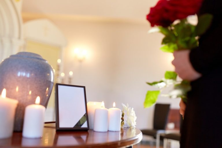 Cremation urn with candles beside