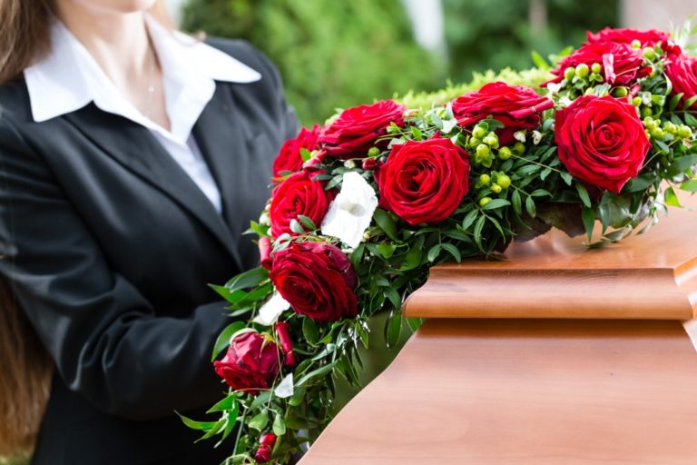 Woman arranging the flowers on a casket