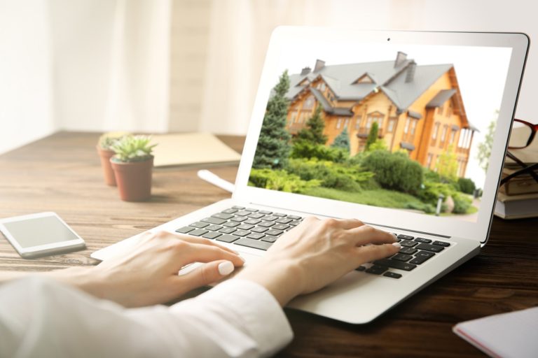 woman looking at a house on her laptop