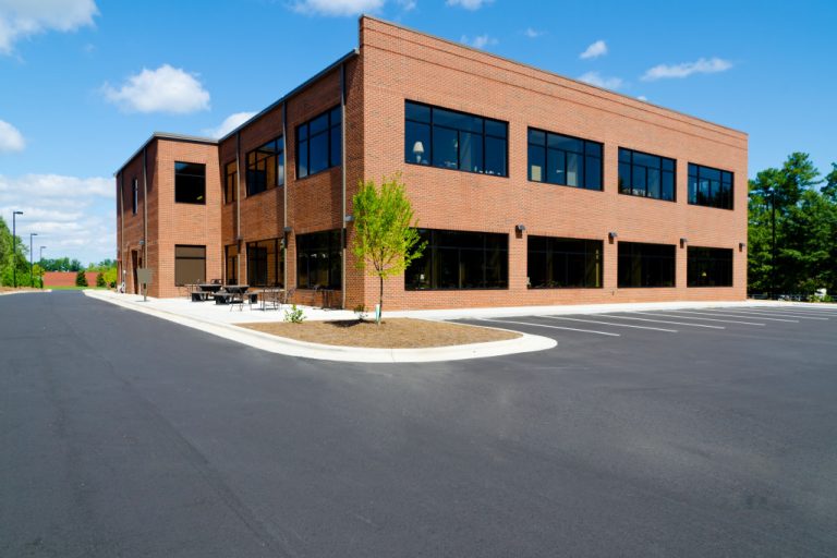 A brick office building with a parking lot