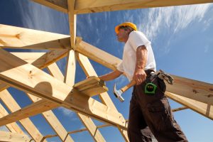 man in a roof frame for house construction